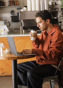 Typ arbeitet und trinkt Kaffee